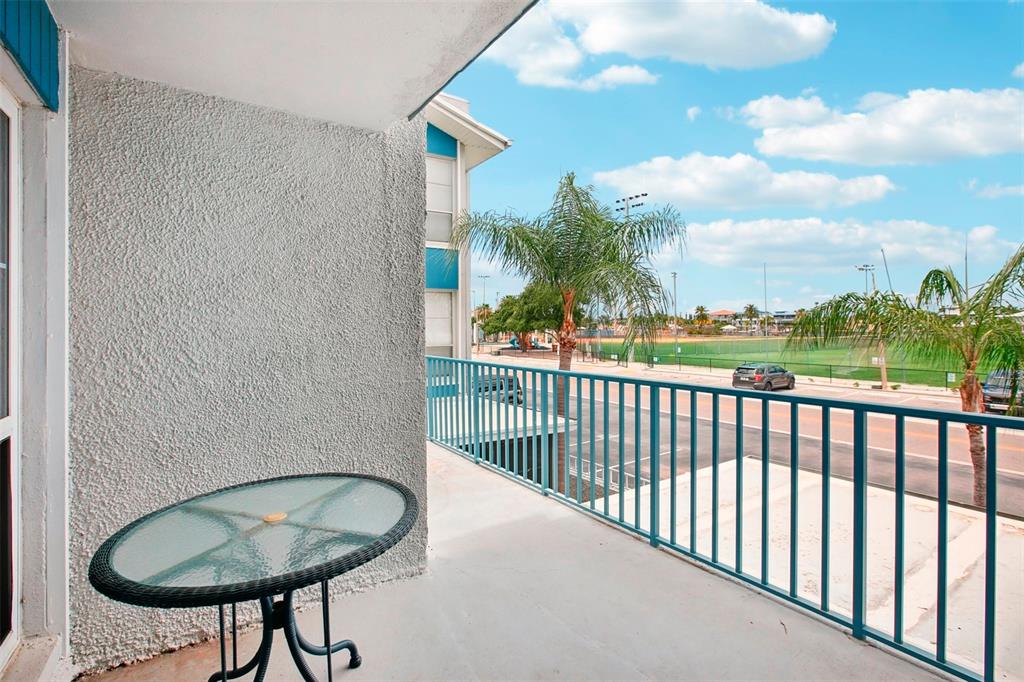 343 Rex Place, Unit F Madeira Beach, FL 33708 - Photo 6 of 28 a balcony with table and chairs