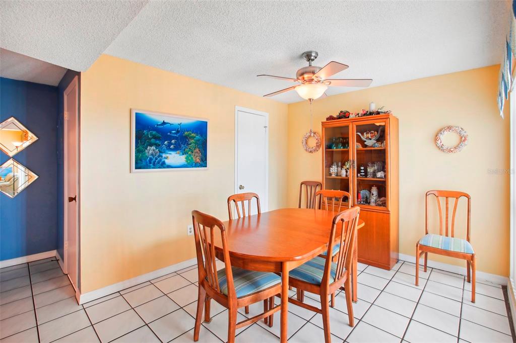 343 Rex Place, Unit F Madeira Beach, FL 33708 - Photo 10 of 28 a dining room with furniture and chandelier