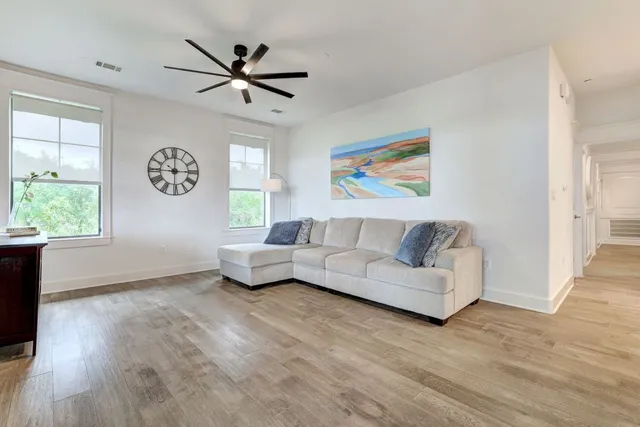 a living room with couches and a large window with wooden floor