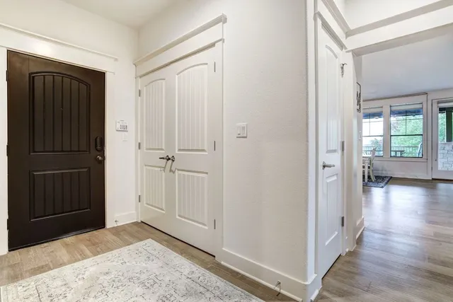a view of a hallway with wooden floor and closet area