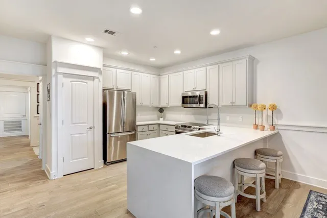 a kitchen with white cabinets and stainless steel appliances