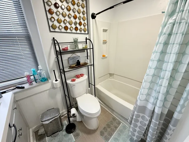 a bathroom with a toilet and a shower