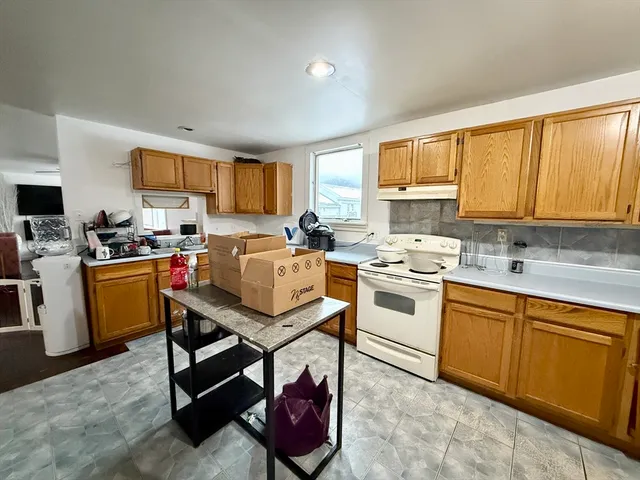 a kitchen with a stove a sink a microwave and a refrigerator