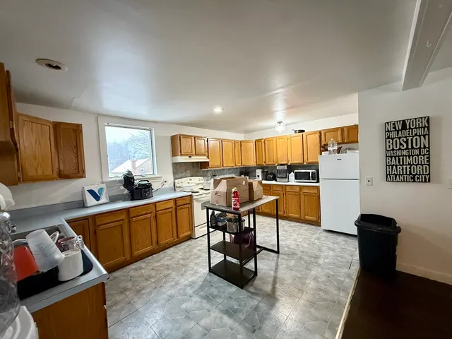 a kitchen with furniture a refrigerator and a view of living room