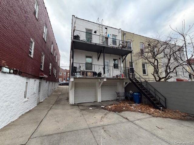 1826 Edison Avenue Bronx, NY 10461 - Photo 25 of 27 Back of house with stairs, concrete driveway, an attached garage, and covered porch
