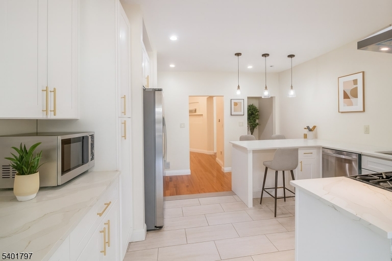 187 Littleton Avenue, Unit 1 Newark, NJ 07103 - Photo 5 of 22 a kitchen with stainless steel appliances kitchen island granite countertop a refrigerator and a sink