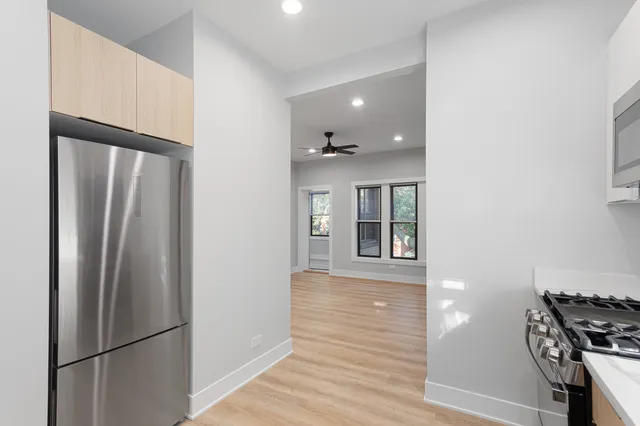 a view of a kitchen with a refrigerator and wooden floor