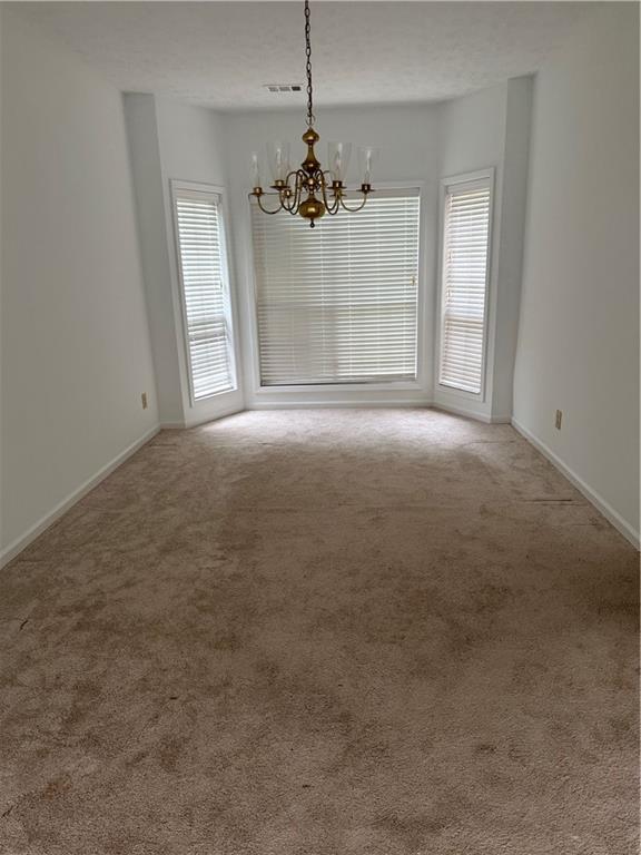 682 Bridge Way Lithonia, GA 30058 - Photo 4 of 25 en empty room with windows and chandelier
