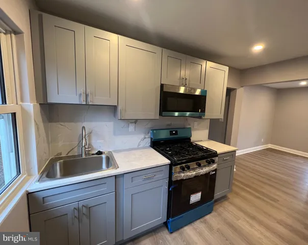 a kitchen with stainless steel appliances a stove a sink a refrigerator and cabinets