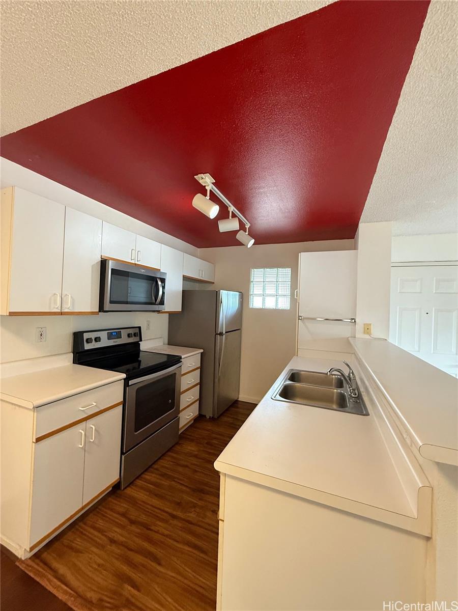 91-1199 Kaneana Street, Unit 2D Ewa Beach, HI 96706 - Photo 4 of 12 a kitchen that has a sink and a stove in it