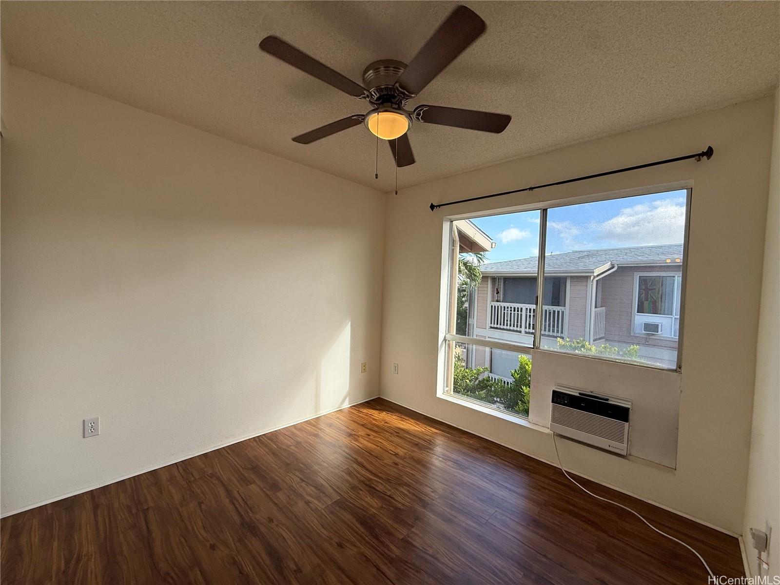 91-1199 Kaneana Street, Unit 2D Ewa Beach, HI 96706 - Photo 6 of 12 wooden floor in an empty room with a window