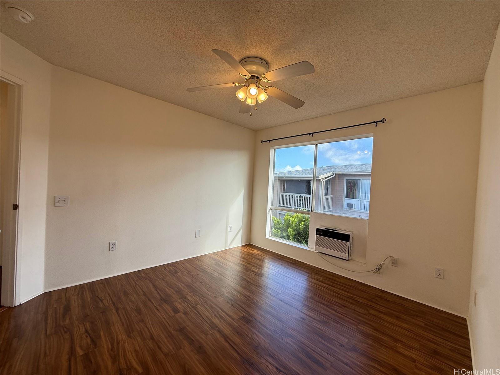 91-1199 Kaneana Street, Unit 2D Ewa Beach, HI 96706 - Photo 9 of 12 wooden floor in an empty room with a window