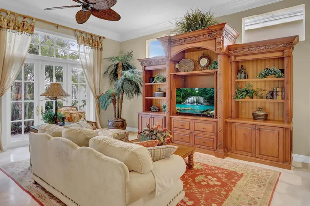 a living room with furniture a flat screen tv and a floor to ceiling window