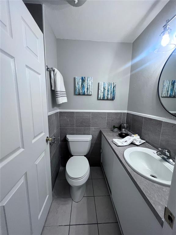 3857 West University Avenue Gainesville, FL 32607 - Photo 11 of 17 a bathroom with a granite countertop toilet sink and mirror