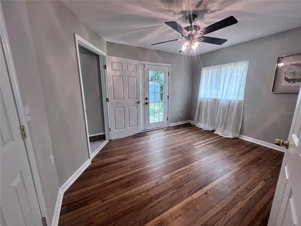 3857 West University Avenue Gainesville, FL 32607 - Photo 5 of 17 a view of an empty room with wooden floor and a window