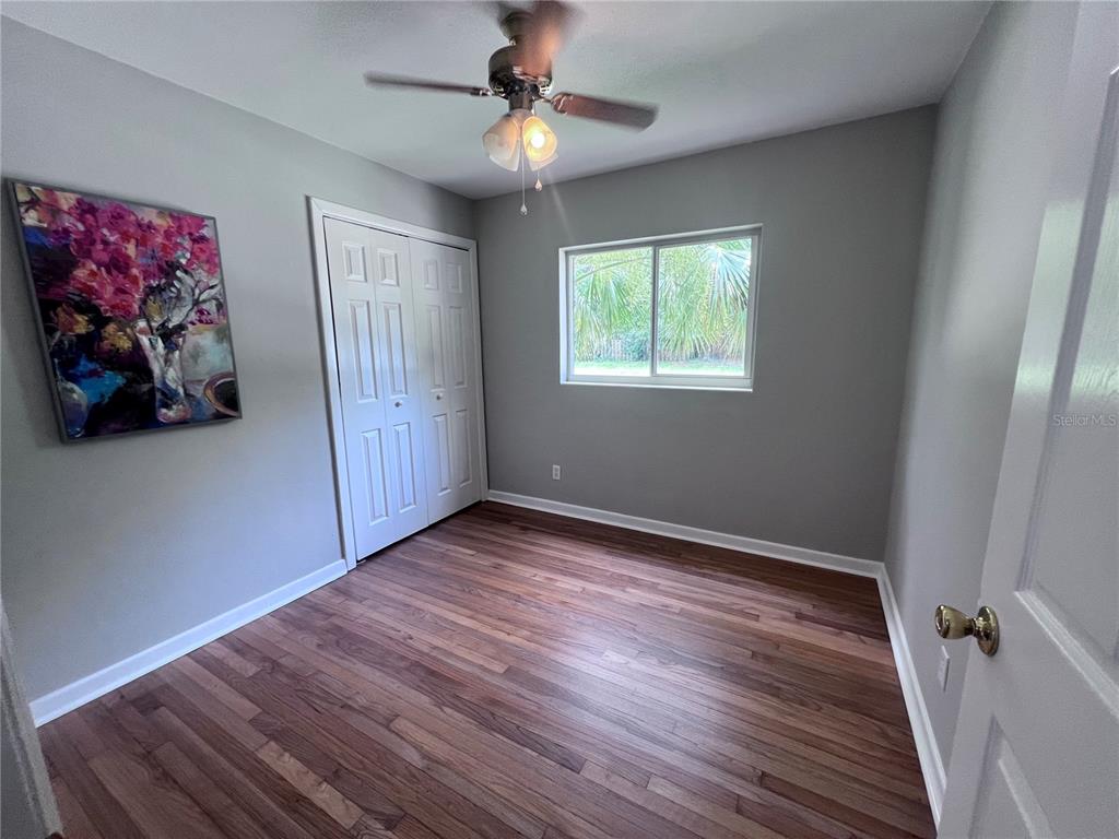 3857 West University Avenue Gainesville, FL 32607 - Photo 6 of 17 a view of an empty room with wooden floor and a window
