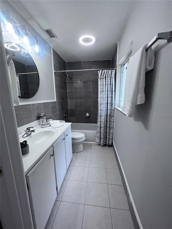 3857 West University Avenue Gainesville, FL 32607 - Photo 9 of 17 a bathroom with a double vanity sink toilet and mirror