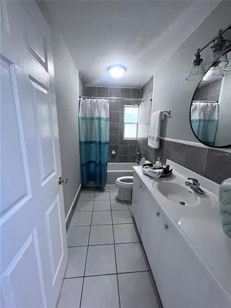 a large white bathroom with a double vanity sink a mirror and a shower