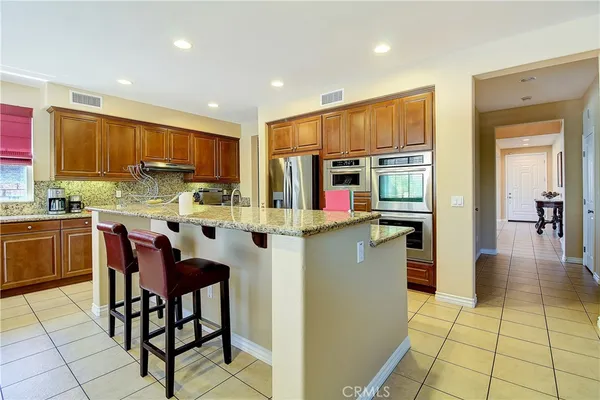 a kitchen with stainless steel appliances granite countertop a stove top oven a sink dishwasher and microwave with wooden floor