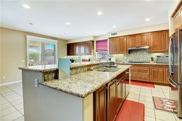 a kitchen with stainless steel appliances granite countertop a sink and a stove