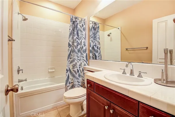 a bathroom with a granite countertop toilet sink and mirror
