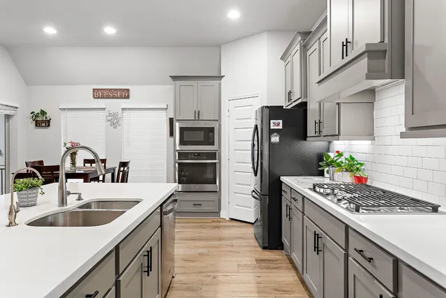 a kitchen with stainless steel appliances a sink stove and refrigerator
