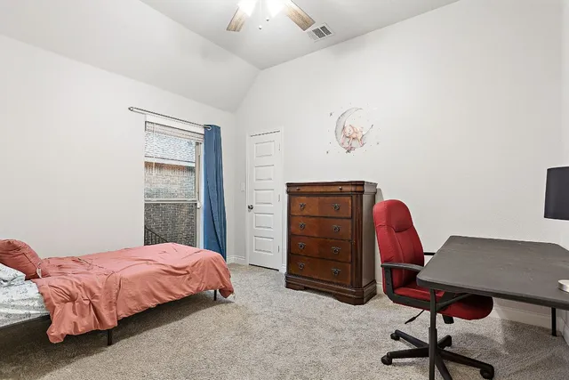 a bedroom with a bed and a desk