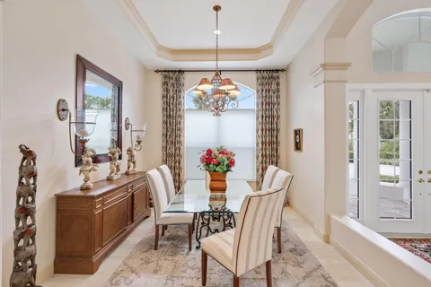 a kitchen with stainless steel appliances kitchen island a table chairs sink refrigerator and cabinets