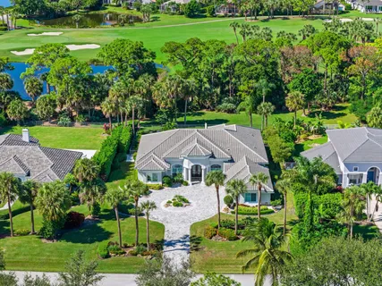 an aerial view of a house with outdoor space and a lake view in back