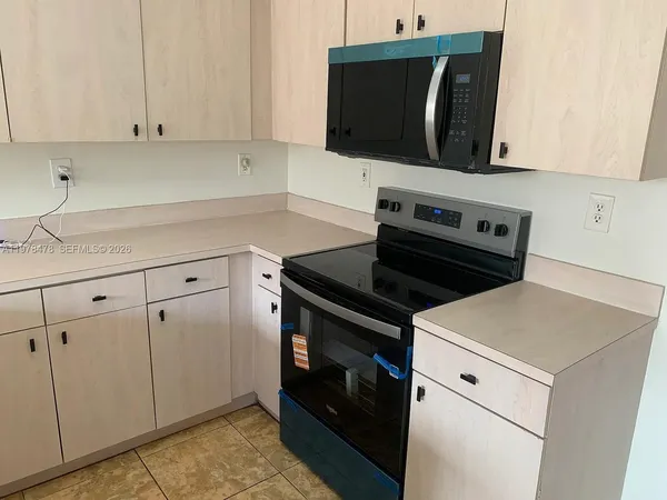 a kitchen with microwave cabinets and stove top oven