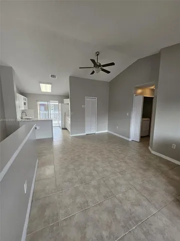 a view of a kitchen with a sink and a refrigerator