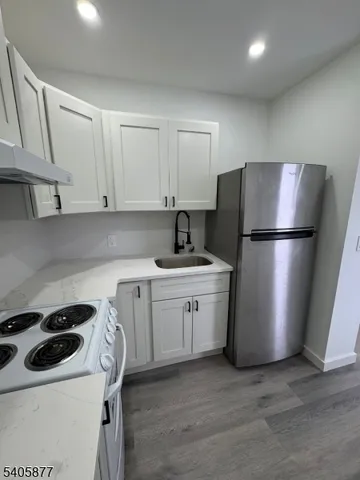 a kitchen with a refrigerator sink and cabinets