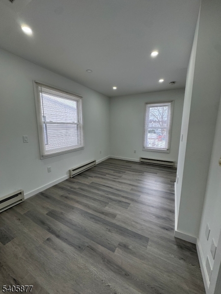 96 Broughton Avenue Bloomfield, NJ 07003 - Photo 5 of 14 an empty room with wooden floor and windows