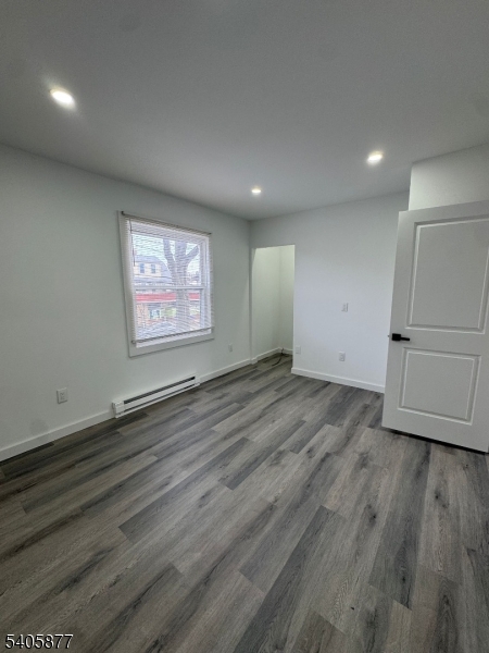 96 Broughton Avenue Bloomfield, NJ 07003 - Photo 6 of 14 an empty room with wooden floor and windows