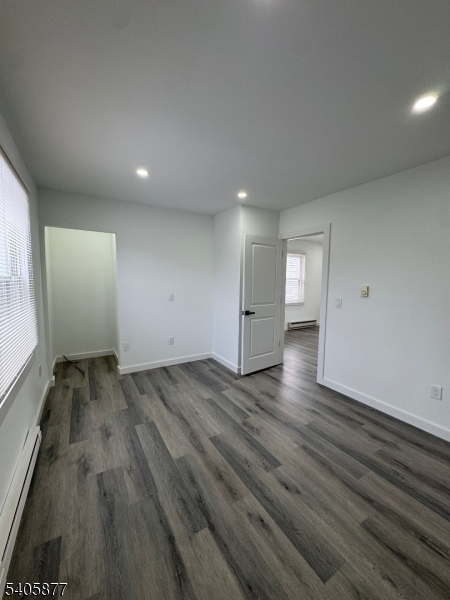 96 Broughton Avenue Bloomfield, NJ 07003 - Photo 8 of 14 an empty room with wooden floor and windows