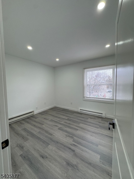 96 Broughton Avenue Bloomfield, NJ 07003 - Photo 10 of 14 an empty room with wooden floor and windows