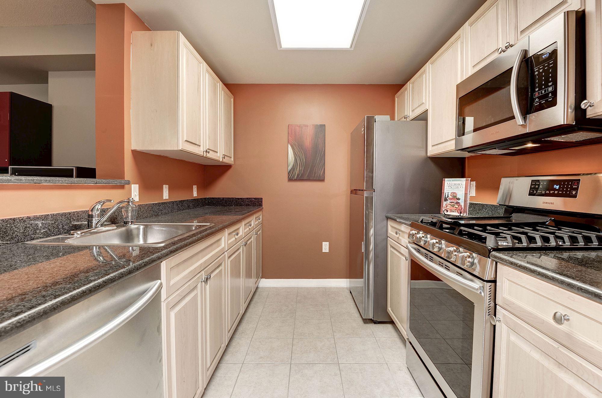 2726 Gallows Road, Unit 1315 Vienna, VA 22180 - Photo 25 of 30 a kitchen with stainless steel appliances granite countertop a stove a sink and a microwave