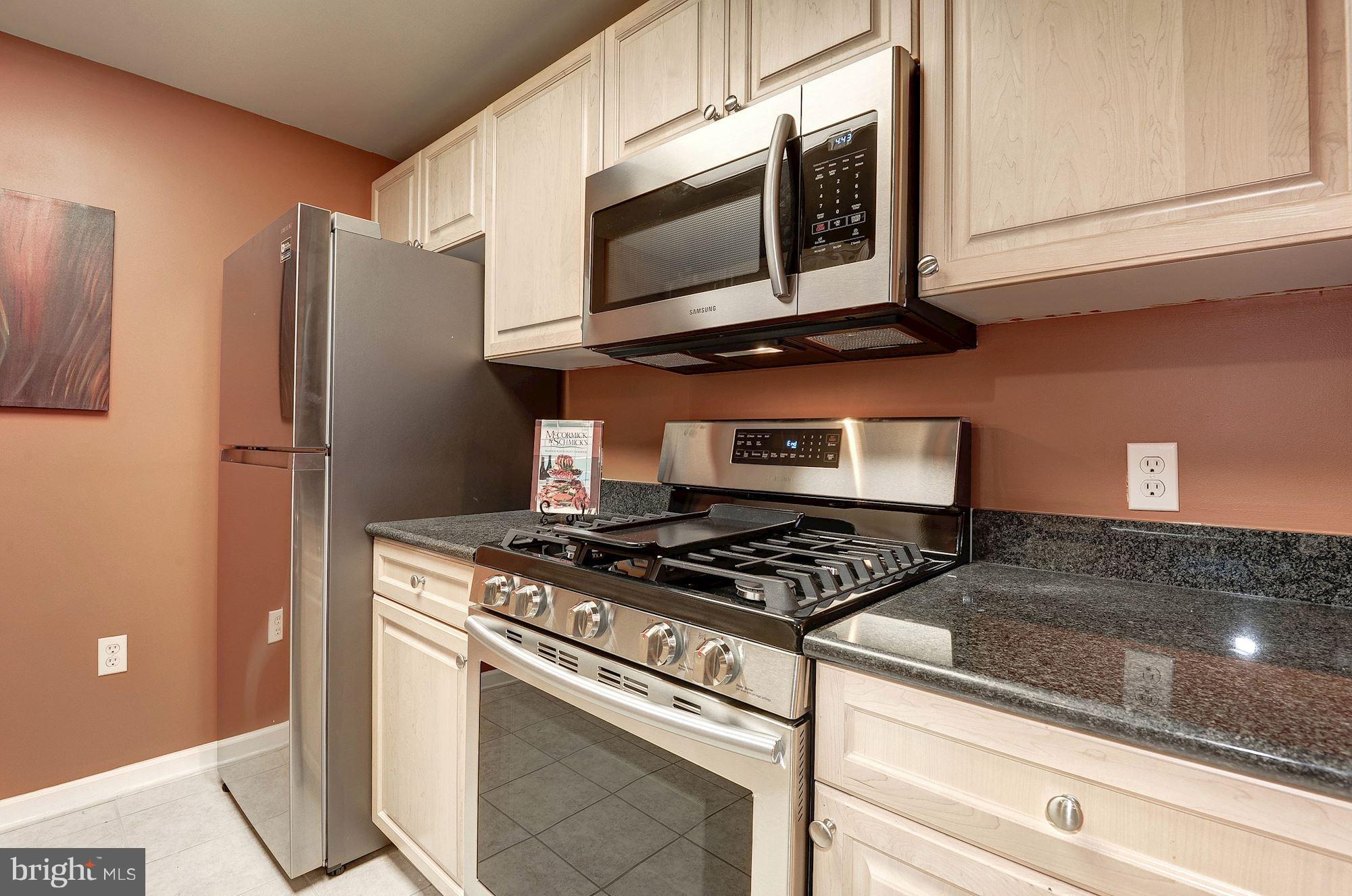 2726 Gallows Road, Unit 1315 Vienna, VA 22180 - Photo 26 of 30 a kitchen with stainless steel appliances granite countertop a stove microwave and refrigerator
