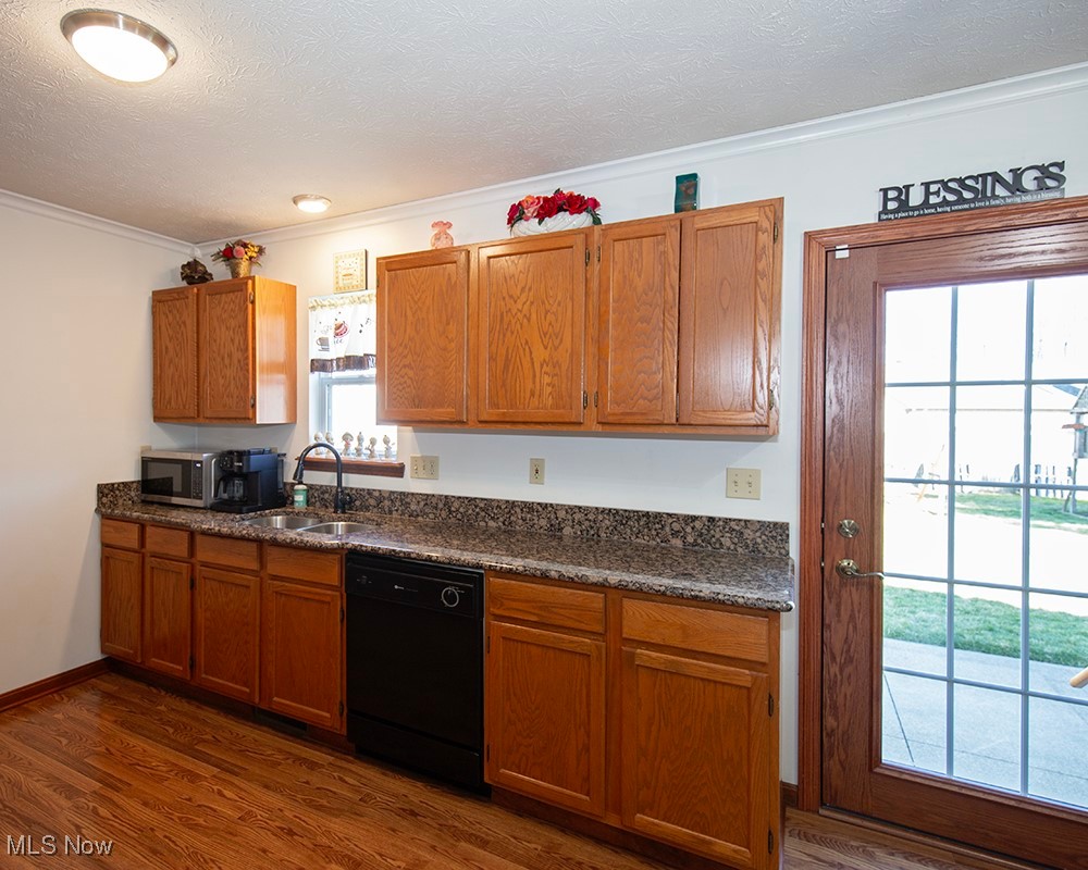 1614 South Abbe Road Elyria, OH 44035 - Photo 4 of 35 Kitchen with a sink, stainless steel microwave, brown cabinets, and black dishwasher
