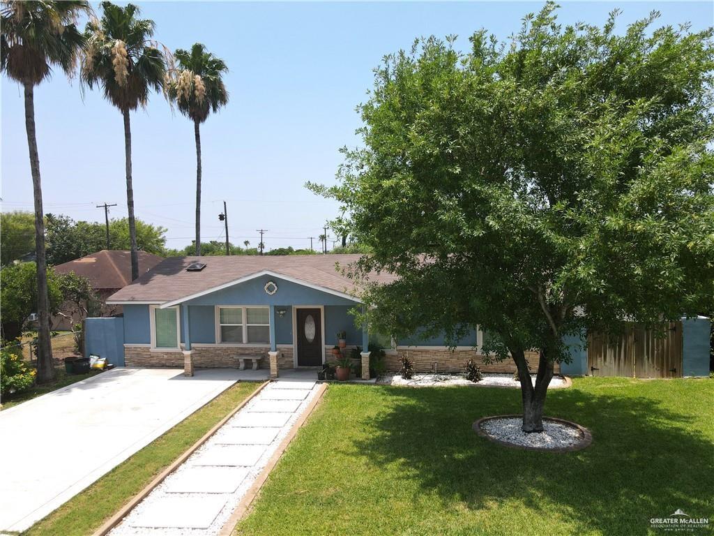 a front view of a house with a yard and palm tree