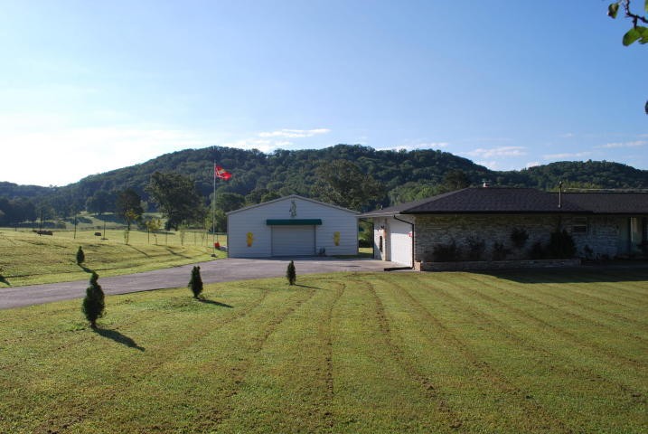 2736 East Raccoon Valley Drive Heiskell, TN 37754 - Photo 2 of 37 a view of a house with a yard and a large tree