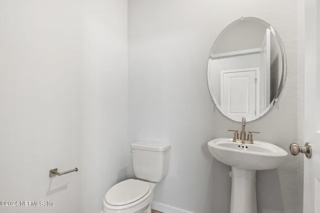 a bathroom with a sink a mirror and a toilet