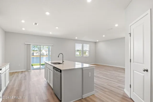 a kitchen with granite countertop sink and refrigerator