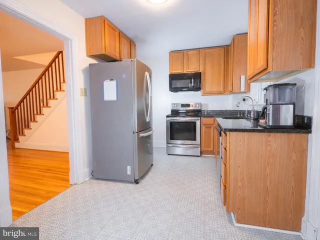 a kitchen with stainless steel appliances granite countertop a refrigerator a stove top oven a sink and dishwasher