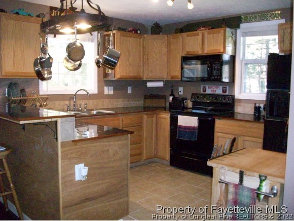 8716 Godwin-Falcon Road Godwin, NC 28344 - Photo 18 of 25 a kitchen with stainless steel appliances granite countertop a stove a sink and a microwave