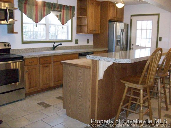 8716 Godwin-Falcon Road Godwin, NC 28344 - Photo 5 of 25 a kitchen with stainless steel appliances a sink cabinets and a window