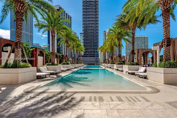 a row of palm trees and swimming pool in the backyard of a house