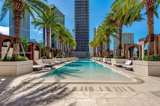 a row of palm trees and swimming pool in the backyard of a house