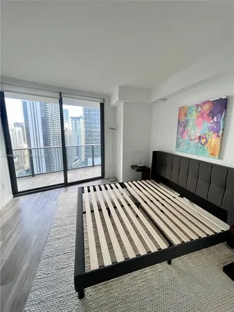 a bed sitting in a bedroom and painting on the wall