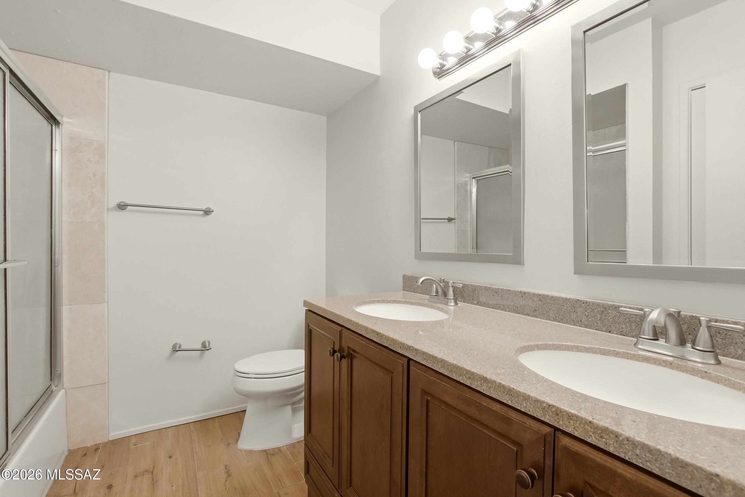 9141 East Indian Canyon Road Tucson, AZ 85749 - Photo 19 of 33 a bathroom with a granite countertop sink a toilet and a mirror